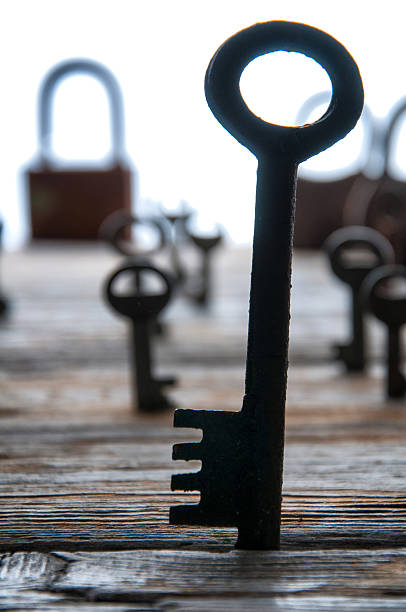 istock Old rusty padlocks and keys on white wooden table 609717380