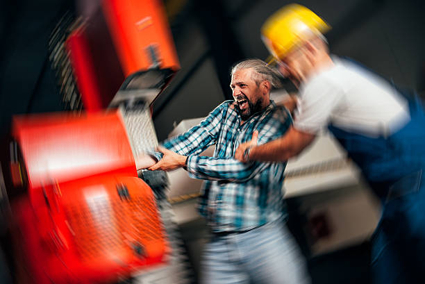 Worker caught in the machine and seriously injured Worker with out safety equipment caught in the machine and seriously injured, other worker is trying to help him hand injury stock pictures, royalty-free photos & images