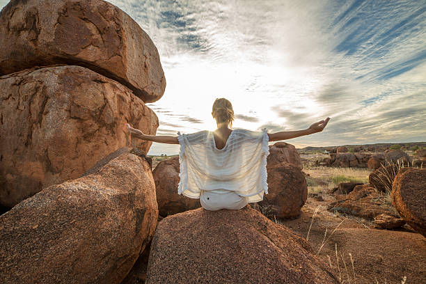 istock Female arms outstretched on boulder at sunset 609724012