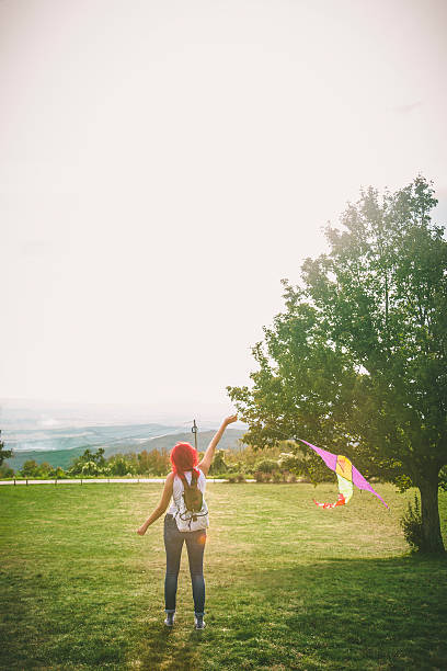 istock Young woman flying a kite 609724096