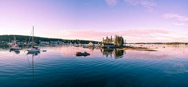 Extreme panorama of a Maine harbor at dawn with sailboats and lobster boats