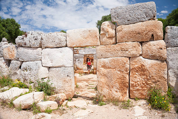 woman tourist visiting prehistoric monument in ancient town from Talayotic times in X century Before Christ, in Torralba den Gaumes or Galmes, in Alaior, Menorca, Balearic Islands, Spain, Europe