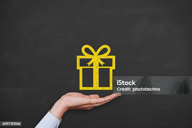 Gift Box Over Human Hand On Blackboard Stock Photo - Download Image Now - Gift, Giving, Art