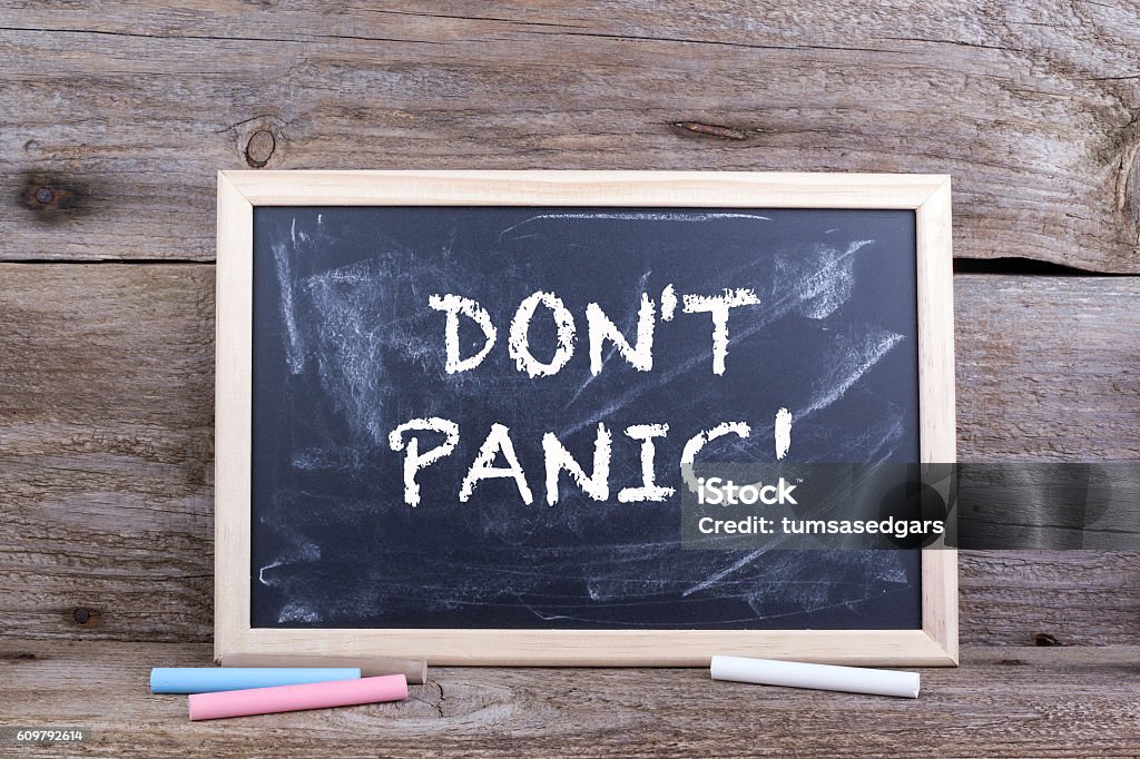 DON'T PANIC! Text on blackboard Terrified Stock Photo