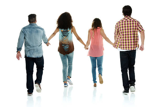 istock Rear view of friends holding hands and walking 609792772