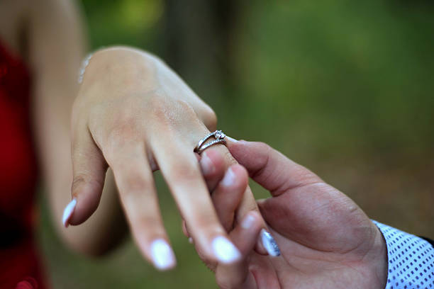 istock Engagement ring on womans hand held by her friend 609794896