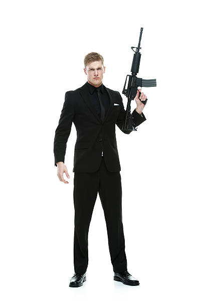 Angry businessman holding rifle Angry businessman holding rifle machine gun stock pictures, royalty-free photos & images