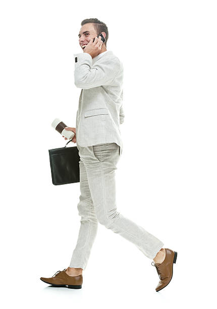 istock Smart casual man on phone and walking 609799404