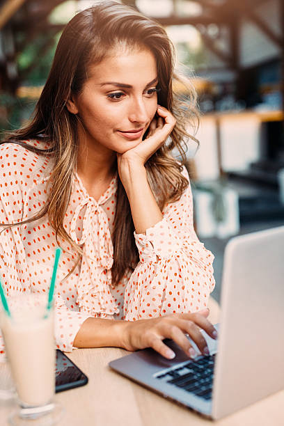 istock Young woman using a laptop at the cafe 609802398