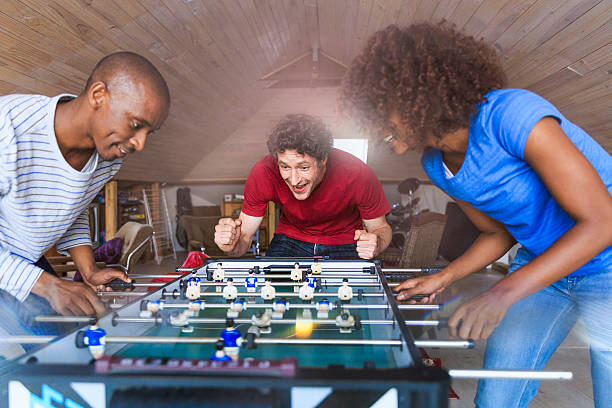 istock Excited man cheering for friends playing foosball 609804562