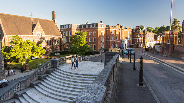 Harrow School in London London, England - August 6, 2016: Traffic and pedestrians pass buildings of the independent Harrow School at Harrow-On-The-Hill in West London. harrow school stock pictures, royalty-free photos & images