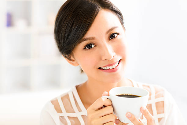 istock young smiling woman drinking coffee in the morning 609806422