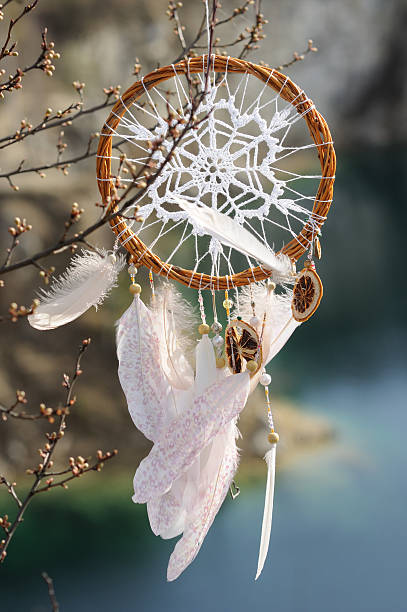 istock Handmade dream catcher with white doily on background of lake 609809314