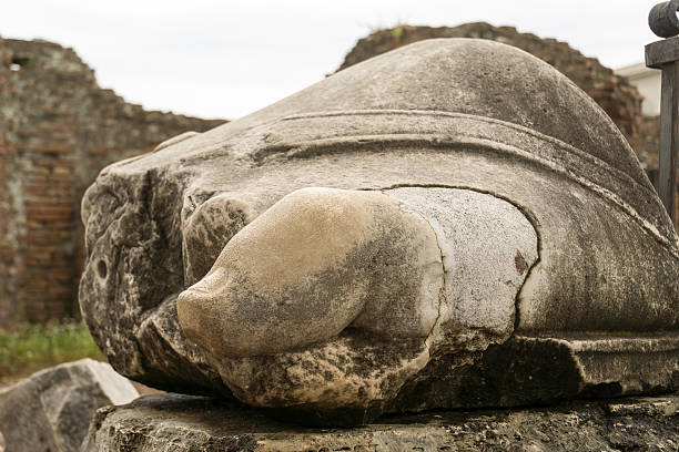 Rear view photo of a female stone torso statue in a stonemason's art studio.