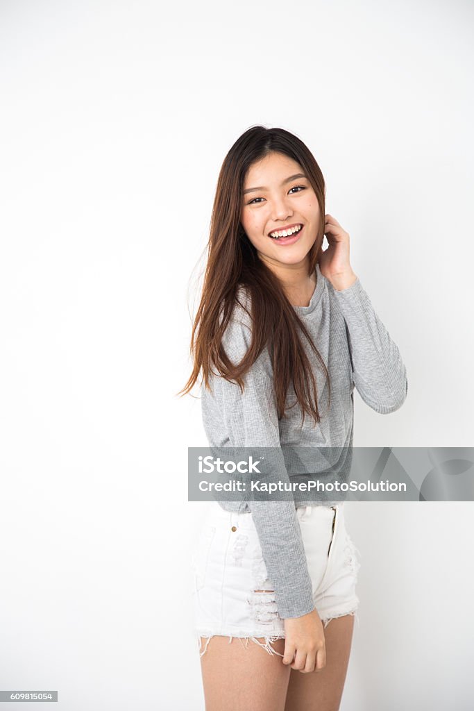 Teenager Asian Girl Young Asian girl smiling with hand on her cheek. Women Stock Photo
