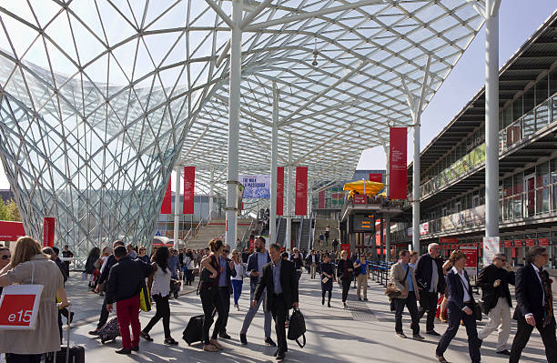 Architectural view of the covered glass roof of Fiera Milano Milan, Italy - April 15, 2015: Architectural view of the covered glass roof of Fiera Milano (before the fair entrance, public square), during Salone del Mobile fair in Milan, with people around fiera stock pictures, royalty-free photos & images