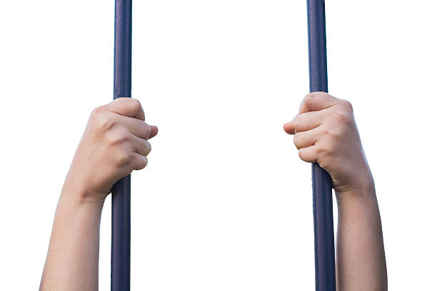 woman hands holding prison bars isolated on white background.