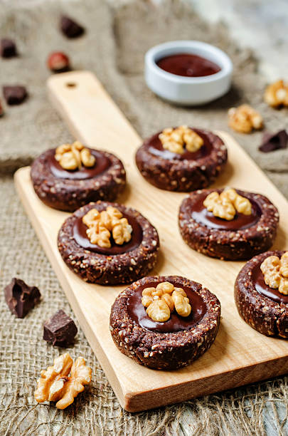 istock Raw vegan chocolate dates hazelnut cookies with chocolate frosting and walnuts 609816640