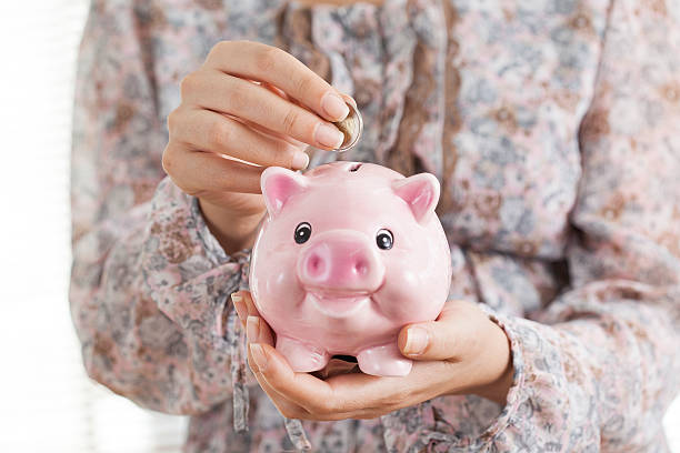 istock Putting coin in piggy bank 609819998