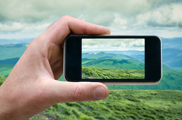 istock phone in a man's hand, mountain landscape photographs on 609820608