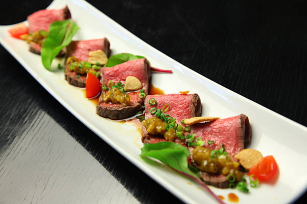 istock Sliced beef steak with onion, tomato and spices on white 609821856