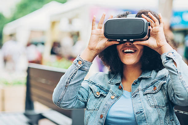 istock Smiling girl looking through a virtual reality headset 609822310