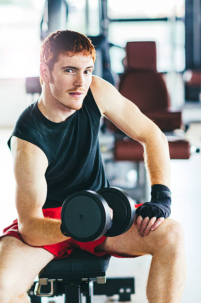istock Red head man training with dumbell on gym 609823464