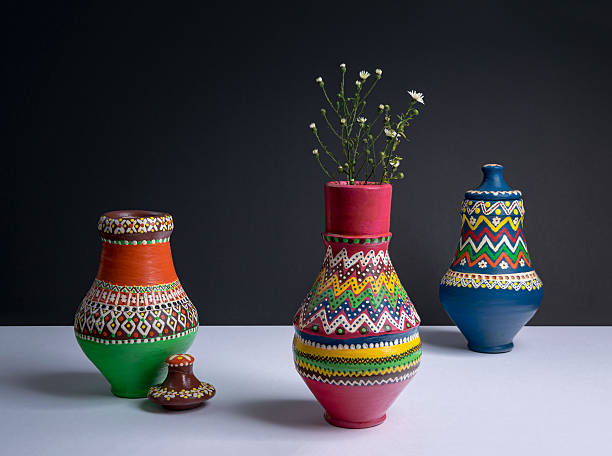 istock Three decorated pottery vases with small flowers with harsh shadow 609824870