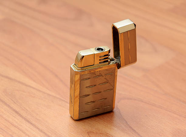 istock Old retro golden lighter closeup on vintage boards 609825234