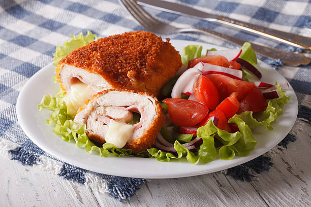 cordon bleu di cotoletta di pollo e insalata su un piatto da vicino - chicken baked chicken breast breaded foto e immagini stock