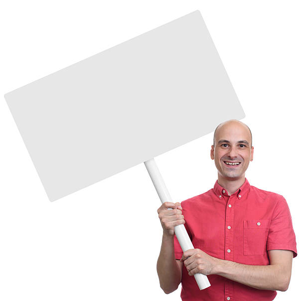 istock Casual bald guy holding blank placard 609827276