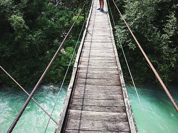 istock Runner on the wooden bridge over the mountain river 609827410
