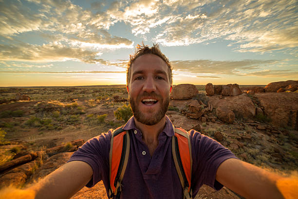 joven toma retrato selfie con espectacular paisaje al amanecer - devils marbles fotografías e imágenes de stock