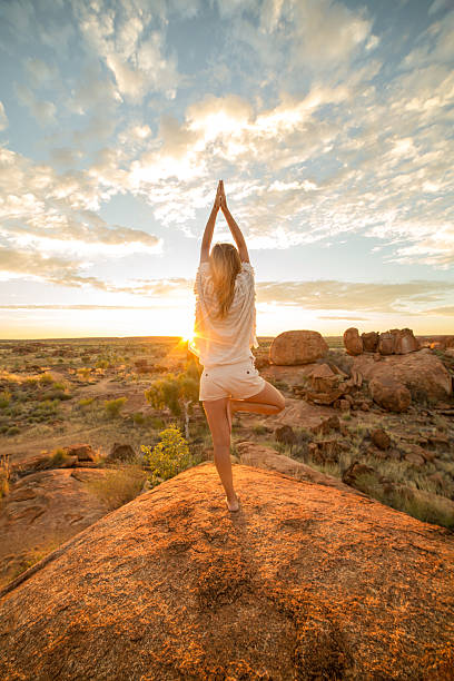 la femelle sur rocher exerce le yoga au lever du soleil - emu australia northern territory outback photos et images de collection