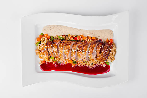 Roasted duck with rice, jasmine and chili sauce on white plate background