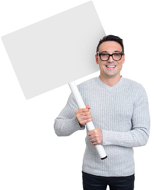 istock Smiling young casual man holding blank placard 609832248