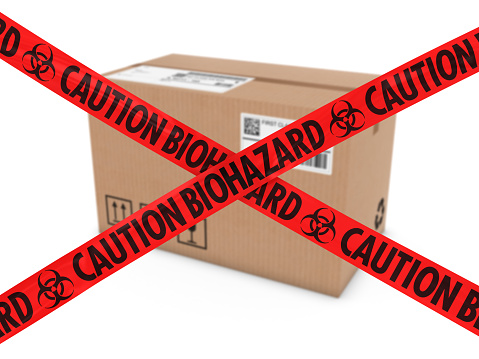 Chemical Attack Parcel Concept - Cardboard Box behind Caution Biohazard Tape Cross