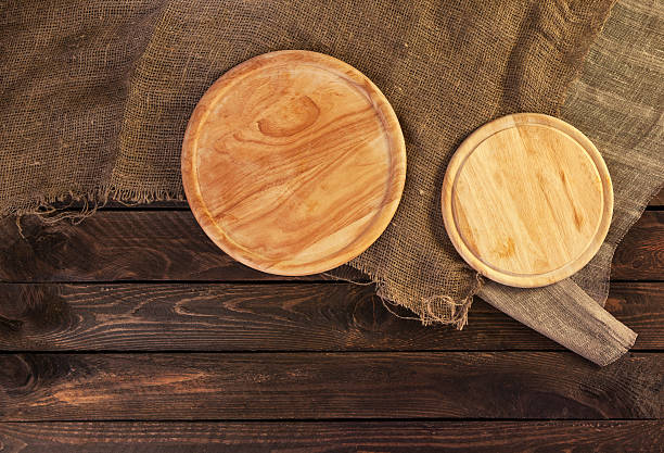 istock Round cutting board on dark wooden table 609837784