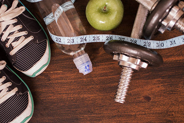 istock Fitness, exercise themed scene with barbells, sneakers, apple. 609901948