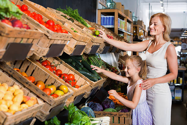 istock Glad mother with daughter shopping various veggies 609902438