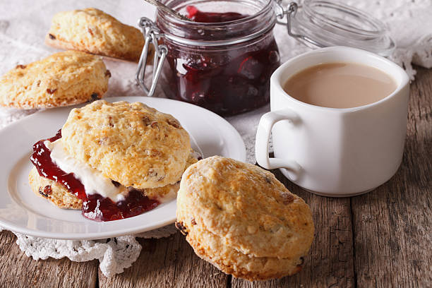 bolinhos com geleia e chá com leite na mesa - tea cakes - fotografias e filmes do acervo