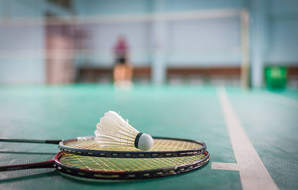 istock Badminton ball (shuttlecock) and racket on court floor 609903412