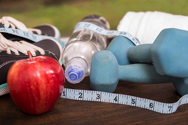 istock Fitness, exercise themed scene with weights, sneakers, apple. 609904228