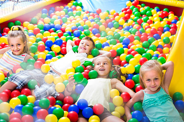 istock children playing together in pool with plastic multicolored ball 609904488