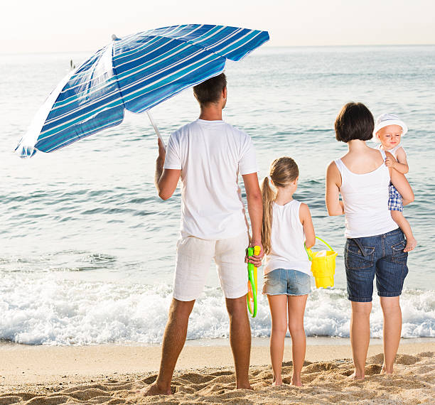 istock Young family of four standing with back forward 609905604
