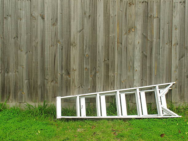 la escalera de aluminio se establece en la cerca de madera para el fondo - escaleras de aluminio fotografías e imágenes de stock