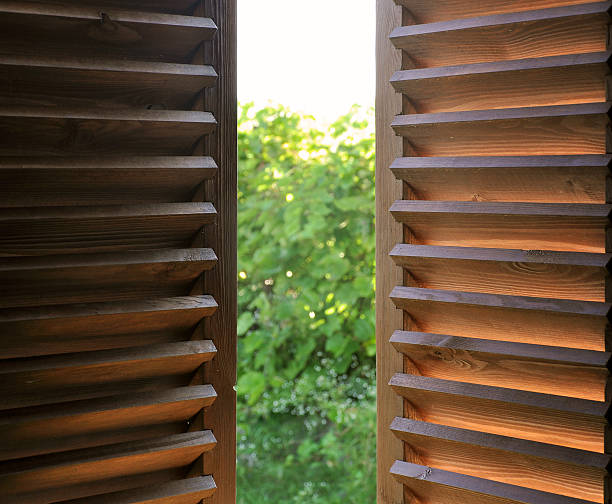 istock Semi-open dark wooden shutters. 609906434