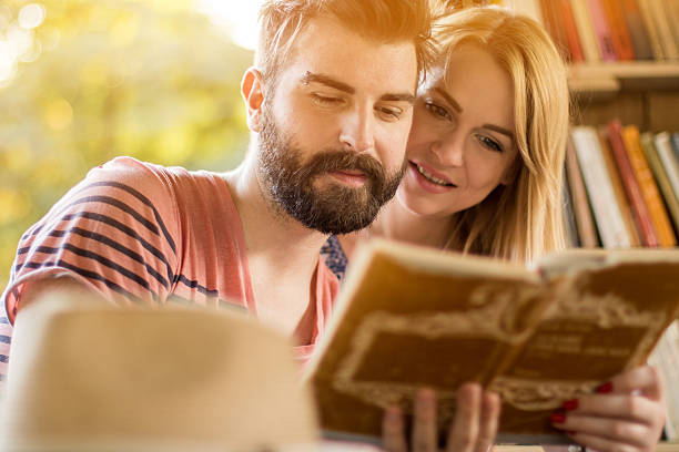 istock Hipster couple with book in natural library 609912572