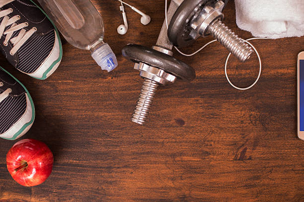 istock Fitness, exercise themed scene with barbells, sneakers, earbuds. 609915810