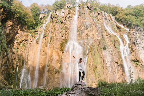 Young Caucasian woman near the waterfall in Plitvice National Park 